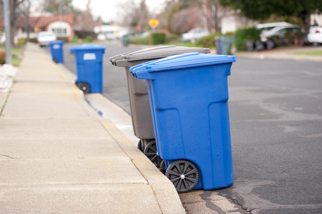 photo of trash bins on the curve-side