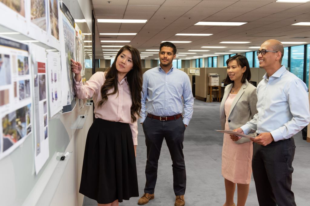 Employees looking at a board in office setting